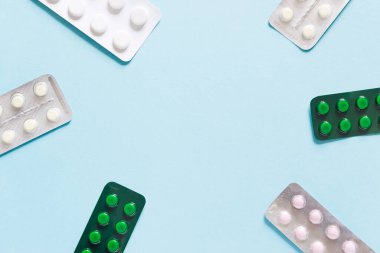 Minimalist tıp ve sağlık konsepti mavi arka planda yassı haplar.