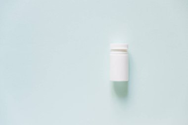 White medicine plastic container on a blue background. Pill bottle mockup. Pharmaceutical packaging. Jar with vitamins and supplements.