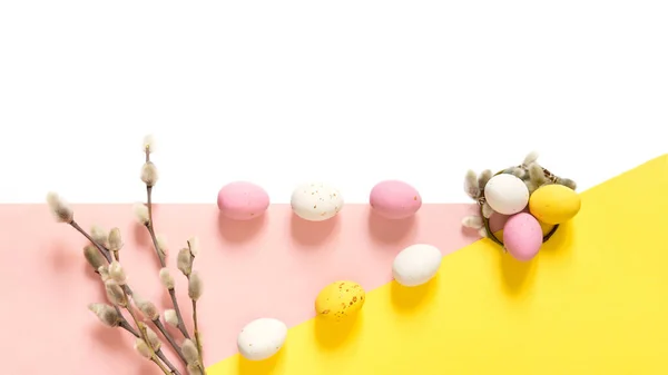 柳の枝とキャンディー明るい白ピンクと黄色の背景にイースターエッグ ハッピー イースター コピースペース — ストック写真