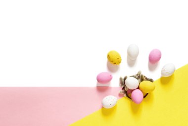candy Easter eggs on a light white-pink and yellow background. Happy easter. copy space
