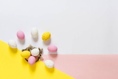 candy Easter eggs on a light white pink and yellow background. Happy easter flat lay. copy space