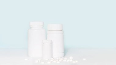 Set of various white medicines, pill bottles without label design, copy space on blue background