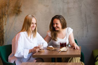 two women sitting in a cafe. Beautiful smiling mother and daughter. Happy mother's day.