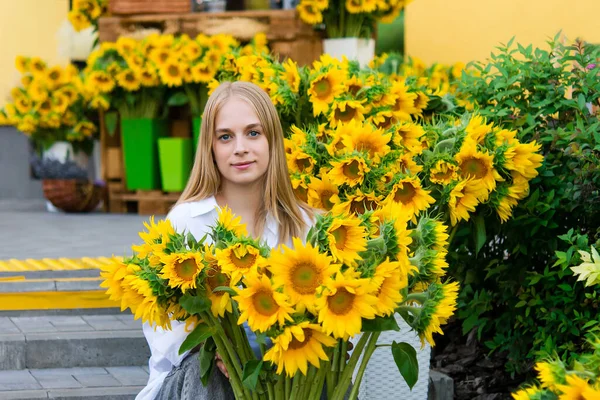 明るい新鮮なひまわりの背景に女の子のティーンエイジャー 新鮮な花の花束を作る花屋さん — ストック写真
