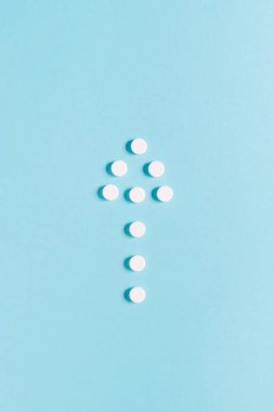 Scattered white pills on blue background. Mock up for special offers as advertising, web background or other ideas. Medical, pharmacy and healthcare concept. copyspace. Empty place for text or logo