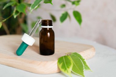 Glass dropper bottle mockup. Body care and spa. Natural cosmetics. skin care bottle. bottle for essential oils and cosmetics lies on a white towel. Dropper. Spa still life with towel, wooden board