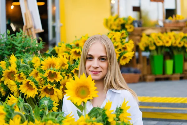 明るい新鮮なひまわりの背景に女の子のティーンエイジャー 新鮮な花の花束を作る花屋さん — ストック写真