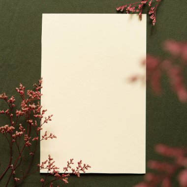 Boş tebrik kartı, davetiye ve zarf modeli. Kuru çiçek ve dallardan yapılmış minimum çiçek çerçevesi. Düz yerde, üst tarafta. Anneler günün, doğum günün, düğün kompozisyonun kutlu olsun. Yeşil keten kumaş.