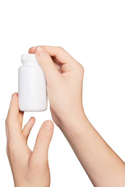 Hands with empty pill bottle isolated on white background. Bottle with pills. Mockup.