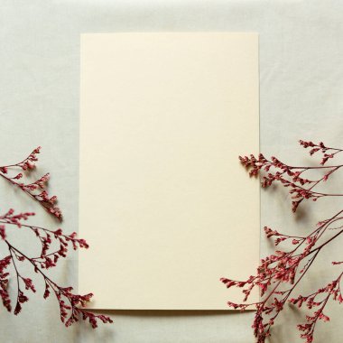 Boş tebrik kartı, davetiye ve zarf modeli. Kuru çiçek ve dallardan yapılmış minimum çiçek çerçevesi. Düz yerde, üst tarafta. Anneler günün kutlu olsun, kadınlar günü veya doğum günün kutlu olsun, düğün kompozisyonu.