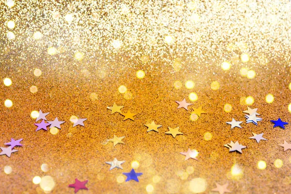 ゴールデンホリデーの背景 メリークリスマスとハッピーニューイヤー 黄金の背景にコンフェッティの星とボケのライトのカラフルな 鮮やかな色のスパンコール グリーティングカード — ストック写真