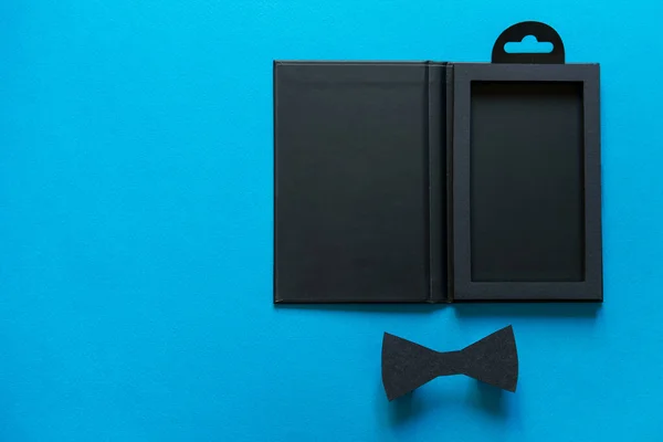 幸せな父の日のコンセプト 黒スタイリッシュなギフトボックスと青の背景に黒紙の弓ネクタイ フラットレイアウト トップビュー コピースペース — ストック写真
