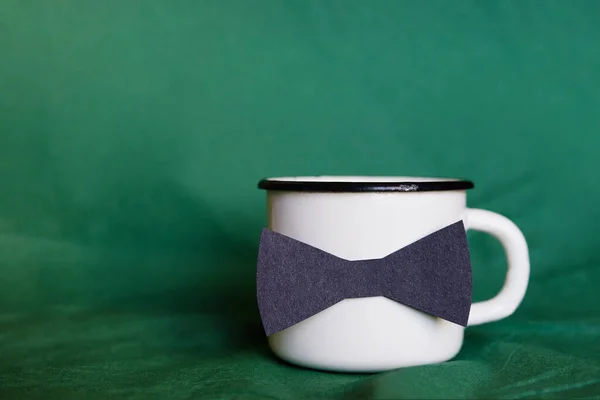 緑の背景に蝶ネクタイのコーヒーカップ 父の日の概念 — ストック写真