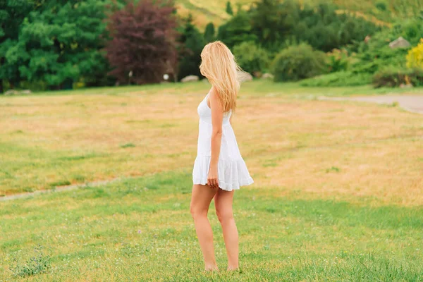 夏天暖和的一天 女人穿着一件白色的短裙赤脚在公园里走着 乡村风景 没有脸 从后面看 — 图库照片