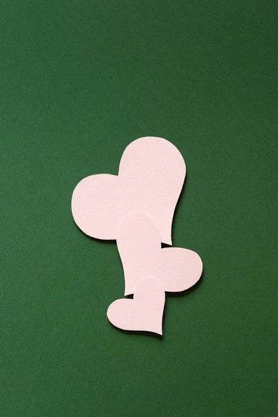 情人节或婚礼的模拟场景 有心形空白卡片 绿纸背景上有三颗粉色纸心 — 图库照片