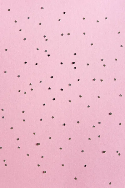 ホリデーグリーティングカード クリスマス シルバーの星の形をした新年パーティーのモックアップシーンは コンフェッティと空のスペースを輝かせます ピンクの紙の背景 — ストック写真