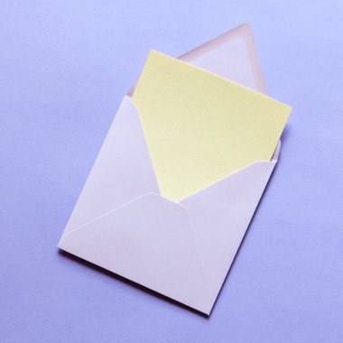 Boş tebrik kartı maketi. Mavi kağıdın arka planında mavi bir zarfın içinde bej boş kağıt maketi. Düz yatıyordu. Düğün, iş, doğum günü Hayat sahnesi.