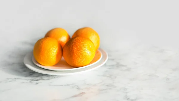 Четыре Апельсина Тарелке Кухне Мраморном Столе — стоковое фото