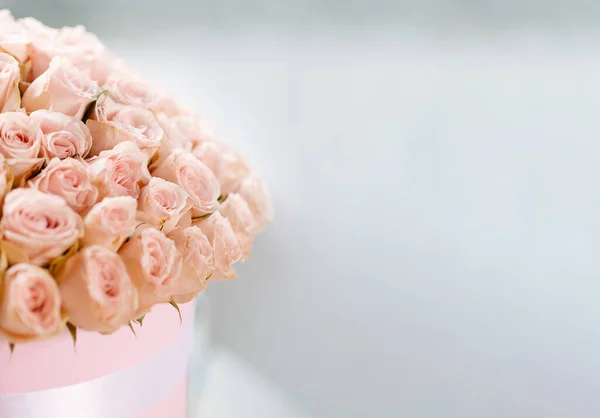 Floral concept. Roses in a bouquet. Flowers in a cylindrical box. Neutral blurred background. Wedding, Birthday, Mother's Day banner. copyspace. mockup.