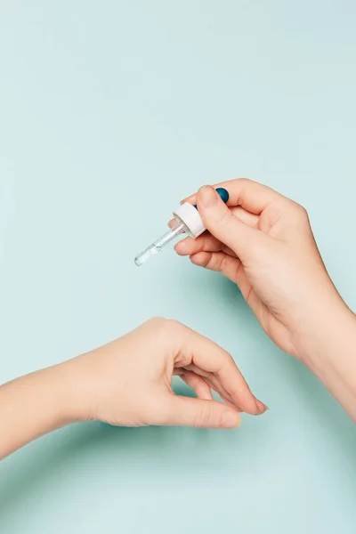 Kadınların Elleri Açık Mavi Arka Planda Kozmetik Serumlu Pipeti Tutuyor — Stok fotoğraf