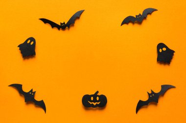 Cadılar Bayramı süslemeleri, yarasalar, balkabağı ve turuncu arka planda hayaletler. Fotokopi alanı olan Cadılar Bayramı partisi tebrik kartı modeli. Cadılar bayramı konseptin kutlu olsun. Düz yatış, üst görünüm