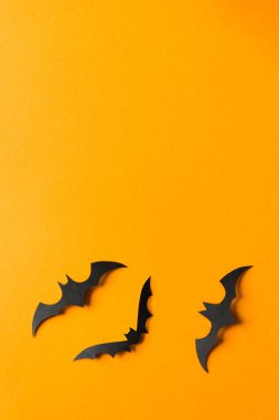 Cadılar Bayramı süslemeleri, turuncu arka planda yarasalar. Fotokopi alanı olan Cadılar Bayramı partisi tebrik kartı modeli. Cadılar bayramı konseptin kutlu olsun. Düz yatış, üst görünüm