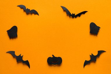 Cadılar Bayramı süslemeleri, turuncu arka planda uçan hayaletlerdeki kağıt yarasalar. Fotokopi alanı olan Cadılar Bayramı partisi tebrik kartı modeli. Cadılar bayramı konseptin kutlu olsun. Düz yatış, üst görünüm