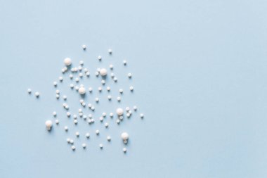 İlaç tabletleri mavi arkaplan ile yakın çekim görüntüsü. Homeopatik yuvarlak haplar. Homeopatik ilaç..