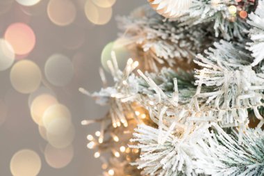 Noel ağacı dalları, süslemeler, toplar, çelenkler, bokeh. Metin için boşluk içeren kartpostal.