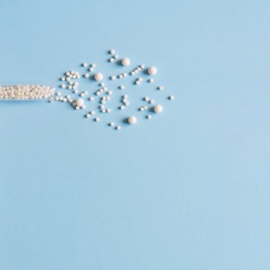 Homeopathic pills and plastic bottle on a blue background. Homeopathic medicine