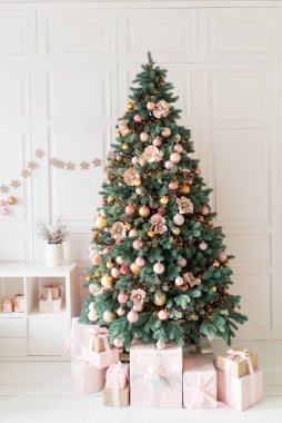 Minimalist hafif bir Noel iç mimarisi, beyaz bir duvar, süslü bir Noel ağacı ve hediyeler. Bayrak tebrik kartı Mutlu yıllar