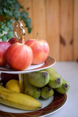 Olgun kırmızı elmalar ve masada bir muz dalı..
