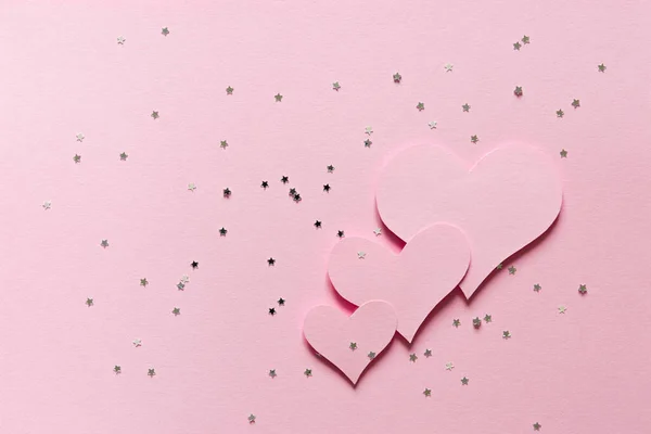 Нежный Розовый Фон Три Розовых Сердца Вырезанные Бумаги Конфетти Звезды — стоковое фото