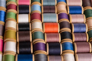 Yukarıdan arka plan dikiliyor. Renkli pamuk iplikçiklerin arka planı. Dikiş işi için malzemeler. Dikiş için çok renkli iplikleri olan raflar