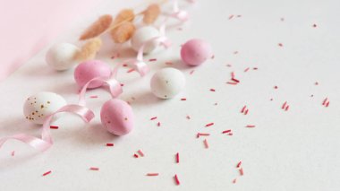 Paskalya minimalist kavramı. Paskalya yumurtası, şeker parçacıkları ve kurdele. Kopyalama alanı olan pastel boş arkaplan.