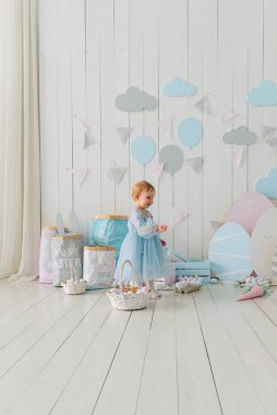 Paskalya günü paskalya yumurtaları ve pastel paskalya dekoru olan neşeli bir kız çocuğu. Yumurta Avı