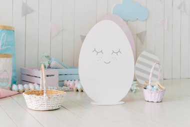 Birçok dekoratif Paskalya yumurtası sepette ve odanın içinde yerde.