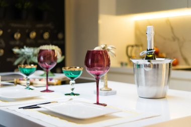 boş renkli şarap bardakları, soğutulmuş şampanya kovası ve masada çatal bıçak takımı. Romantik yemek..