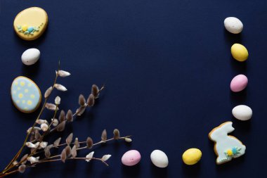 Paskalya pastel yumurtaları ve mavi arka planda söğüt çiçekleri. Boş kopyalama alanı.