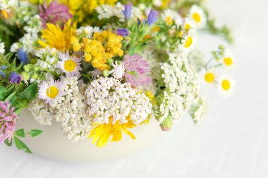 Masadaki keten masa örtüsünün üzerinde bir buket taze, çok renkli yaz çiçeği. Üst görünüm, boş boşluk.