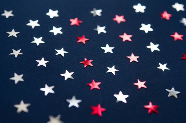 Beyaz (gümüş) ve kırmızı yıldız konfetileri, mavi kağıt arka planda dekorasyonlar