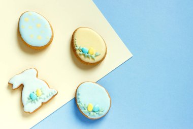 Paskalya kartında zencefilli tavşan ve yumurta var. Kopyalama alanı olan hassas pastel mavi arkaplan. Düz yatıyordu