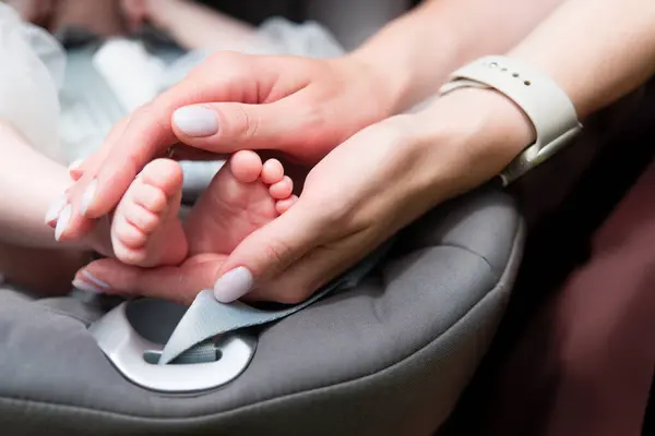 赤ん坊の足は母親の手の中にある ママとその子 ハッピーファミリーと母の日のコンセプト マタニティー 女性の形をした手のクローズアップに生まれた新生児の足 ロイヤリティフリーのストック写真