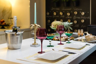boş renkli şarap bardakları, soğutulmuş şampanya kovası ve masada çatal bıçak takımı. Romantik yemek.