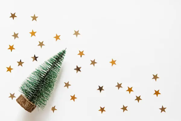 クリスマスツリーと明るい白い背景に星の菓子で新しい年背景 お祝い Xmas デコレーション ゴールドスター Confetti コピースペースの空きスペース フラットレイ トップビュー ロイヤリティフリーのストック画像