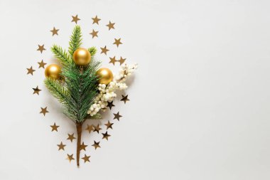 Yılbaşı ağacı, altın oyuncaklar ve açık beyaz arka planda yıldız konfetisi olan yeni yıl arkaplanı. Şenlikli Xmas dekorasyonu, altın yıldızlı konfeti. Kopyalama alanı için boş alan. düz yatış, üst görünüm