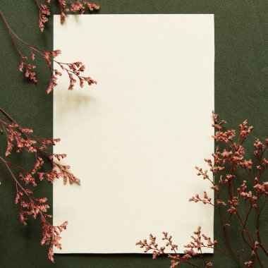 Boş tebrik kartı, davetiye maketi. Kuru çiçek ve dallardan yapılmış minimum çiçek çerçevesi. Anneler Günün kutlu olsun. Düz yatış, üst görünüm. 