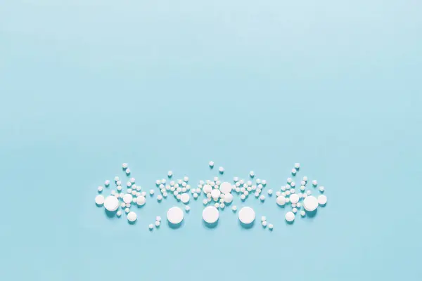Verspreid Witte Pillen Blauwe Achtergrond Mock Voor Speciale Aanbiedingen Als Rechtenvrije Stockafbeeldingen