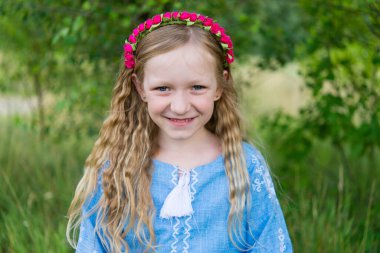 Geleneksel Ukrayna ulusal kıyafetleri içinde neşeli bir kızın portresi - vyshyvanka. Ukrayna, doğadaki çocuk