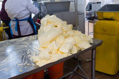 Fabrika tereyağı üretiyor. Süt ürünleri fabrikasındaki ekipman. Tereyağı kesim masasında.